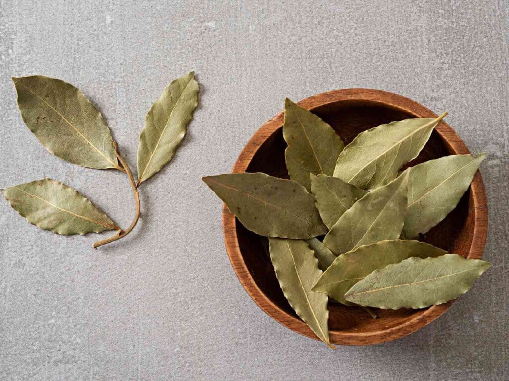 a wooden bowl filled with indian bay leaves
