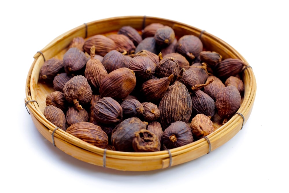 Black Cardamom in a wooden dish