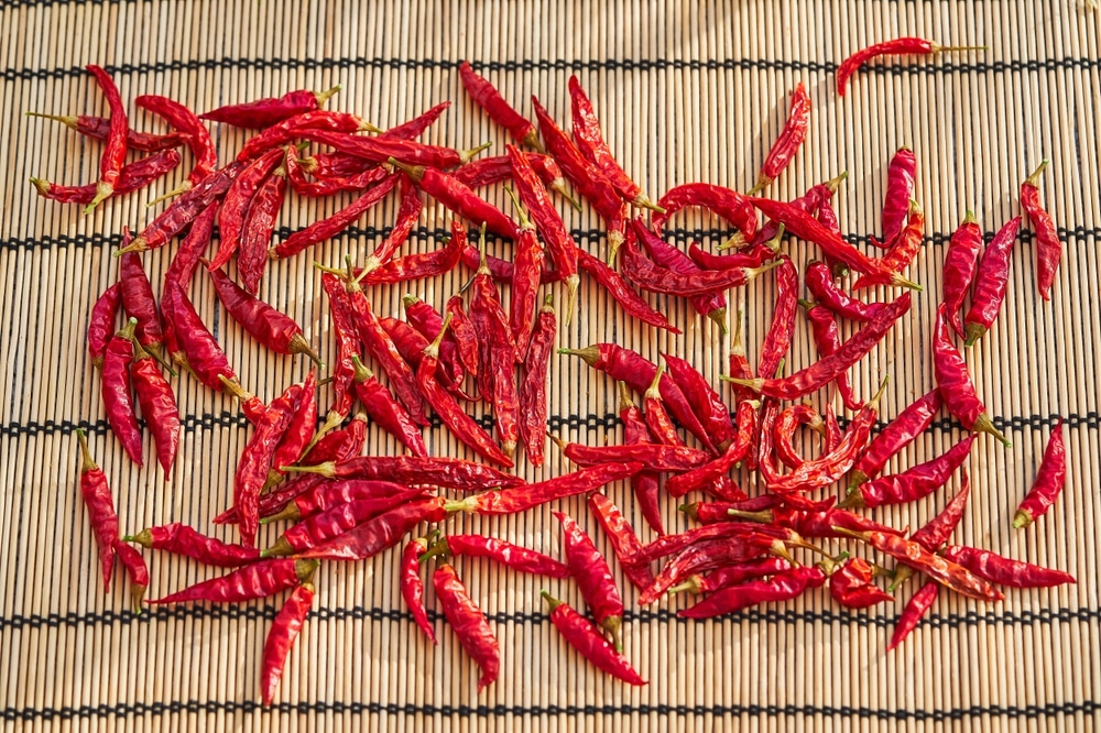 Small Bird's Eye Red Hot Chilli Peppers On Bamboo Mat