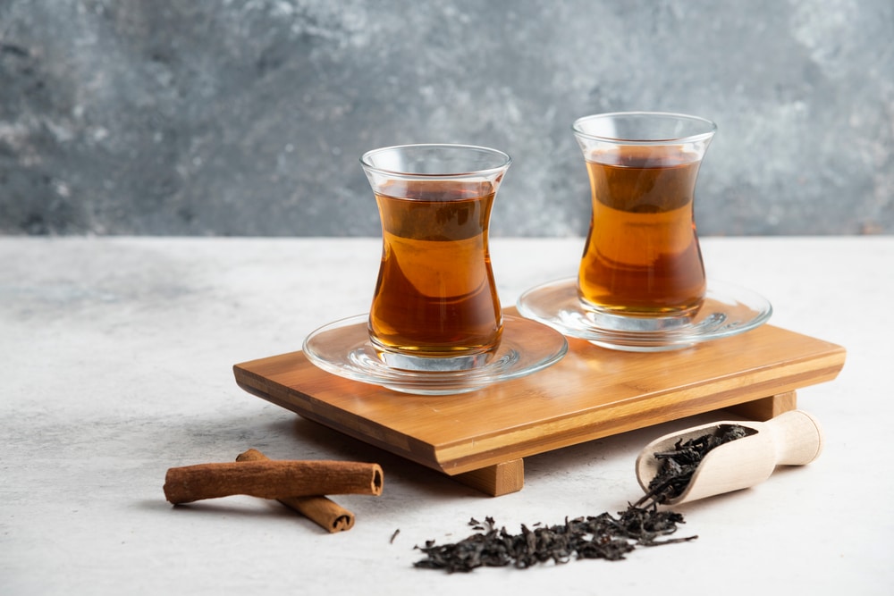 Two Glass Cups Of Tea With Cinnamon Sticks And Loose