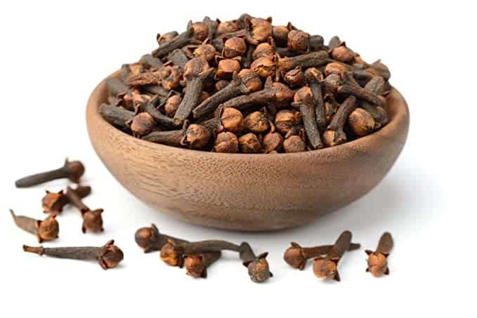 a wooden bowl full of cloves