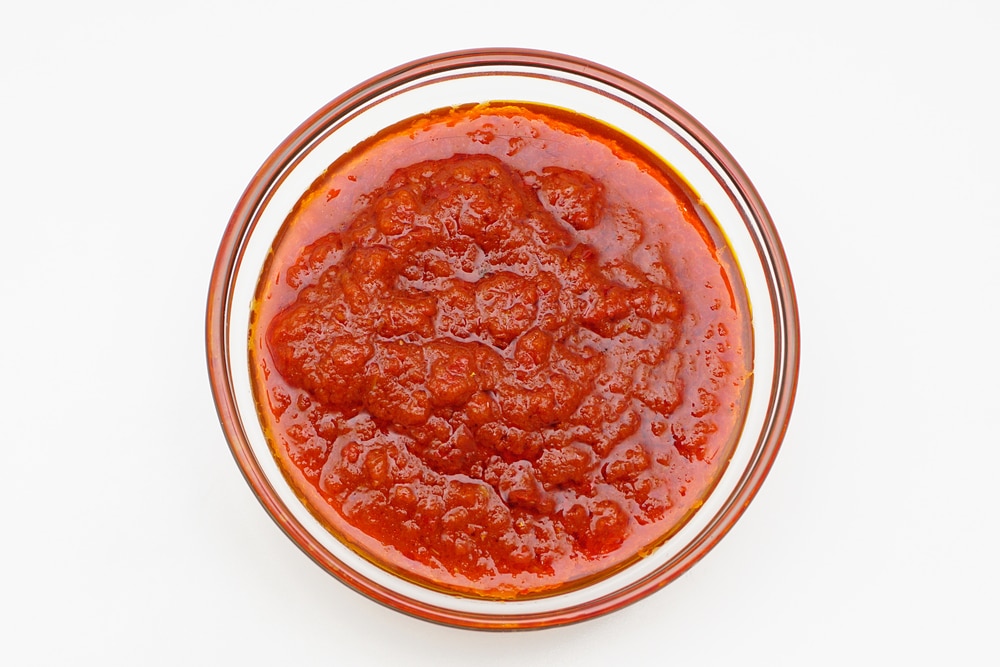 bowl of red hot chili pepper sauce or Malaysian Sambal on white background