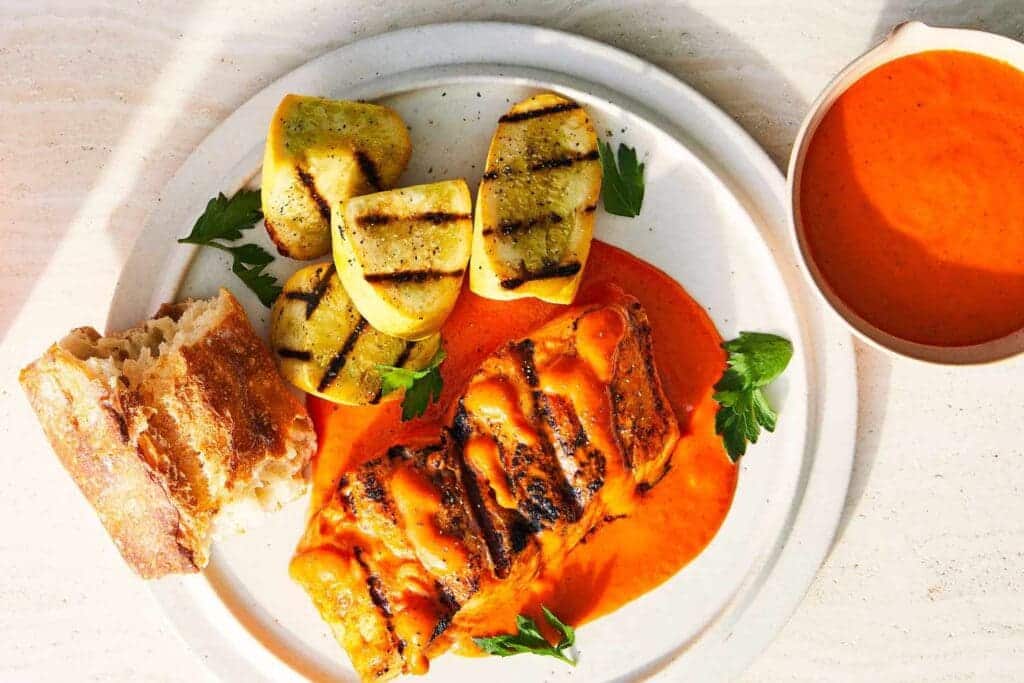 cayenne pepper sauce with a main dish on plate roasted potatoes chicken and bread