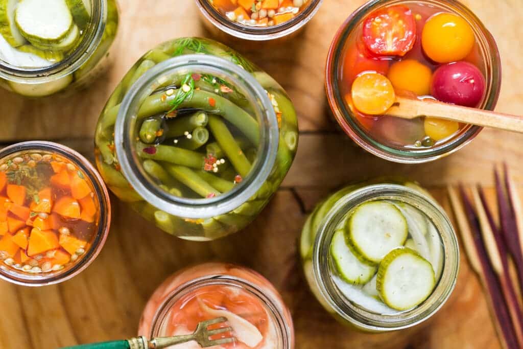 pickle jars of different vegetables with mustard seeeds