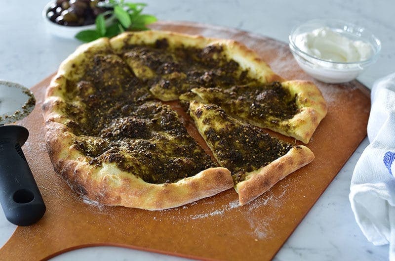 zaatar flatbread cut in pieces placed on a wooden tray