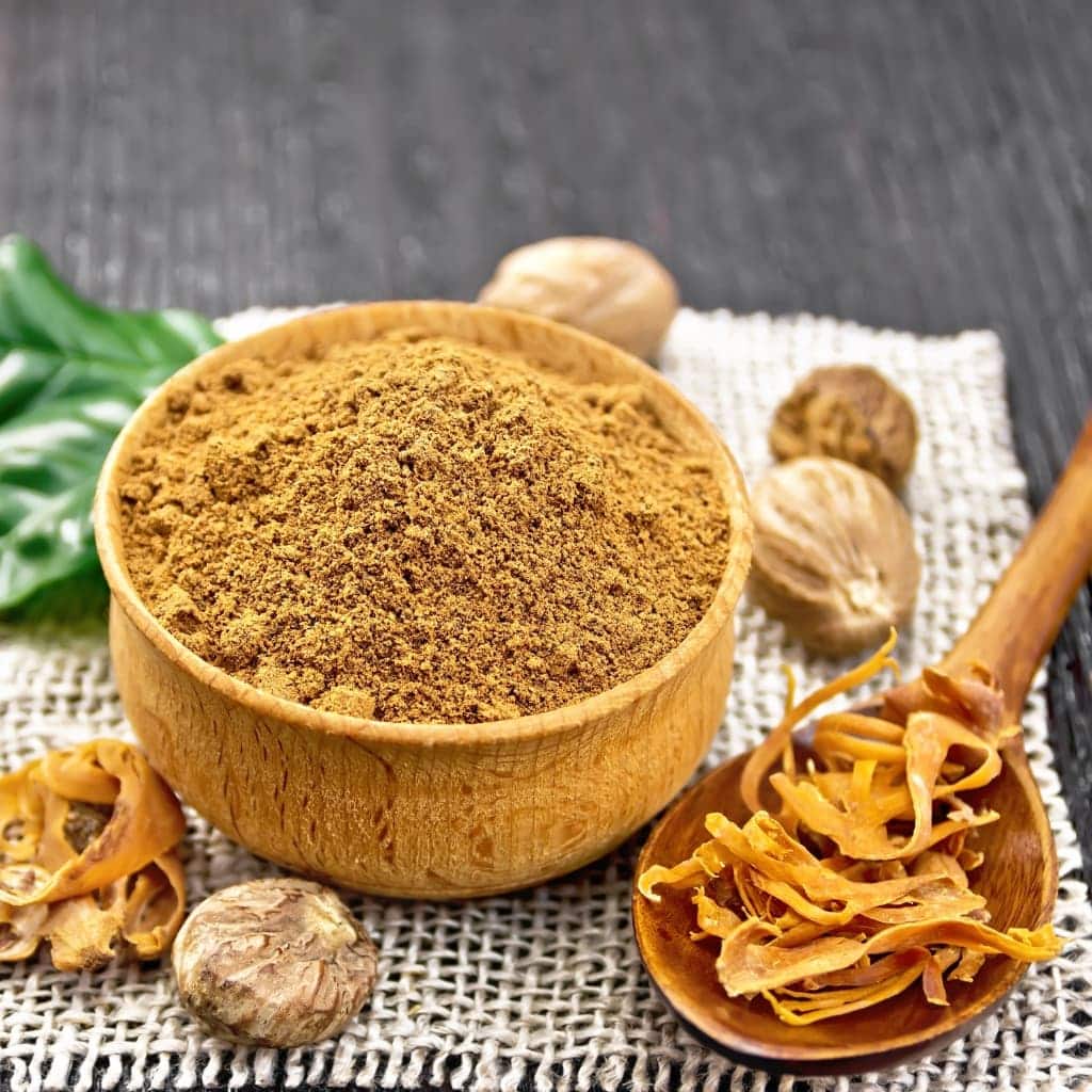 a jar full of mace spice along with some spice lying nearby on the surface