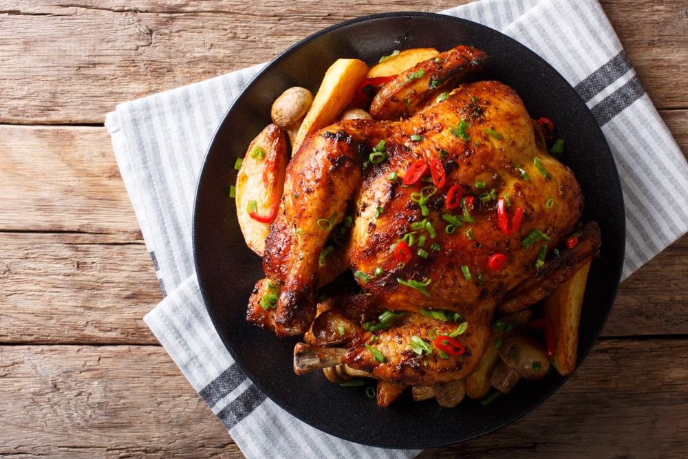 Baked Whole Chicken With Mushrooms And Potatoes Close up On A table 