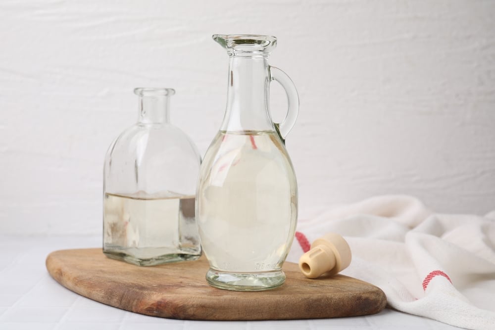 Vinegar In Glass Jug And Bottle On White Table