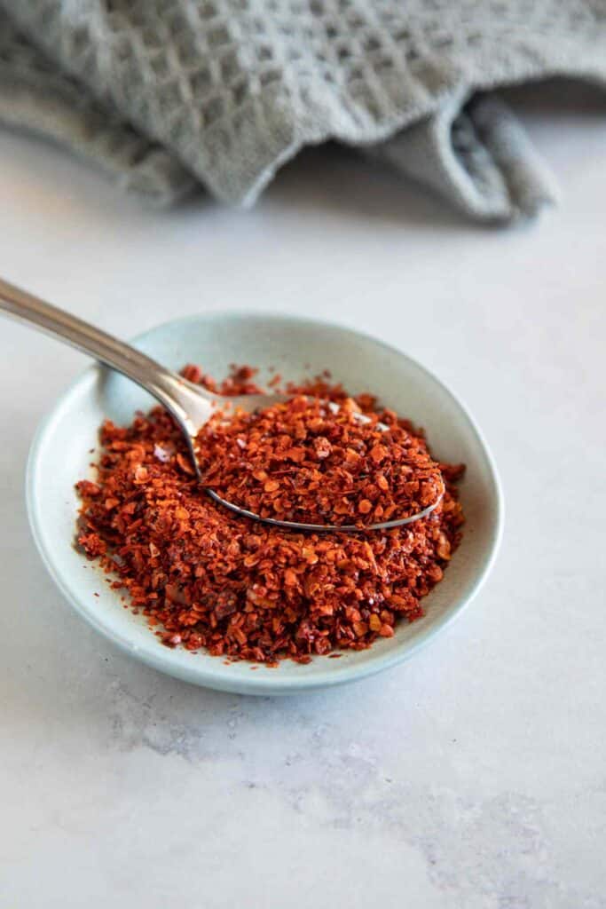 aleppo pepper in a small bowl with a spoon