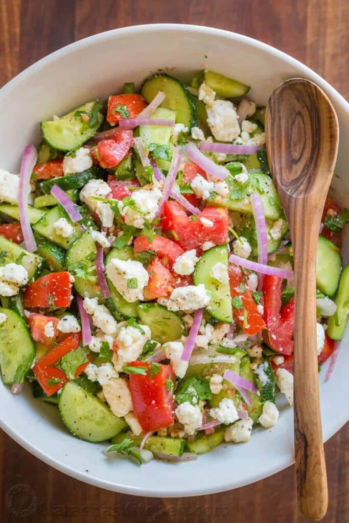 feta salad in a bowl with wooden spoon