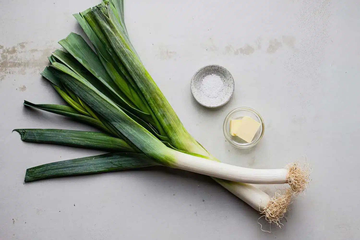 leeks placed with salt and butter on a surface