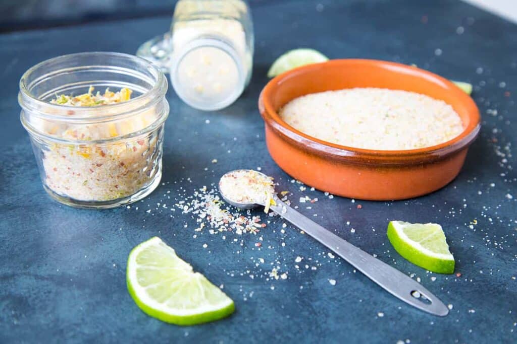 lemon wedges placed on a blue surface lime salt in small bowls