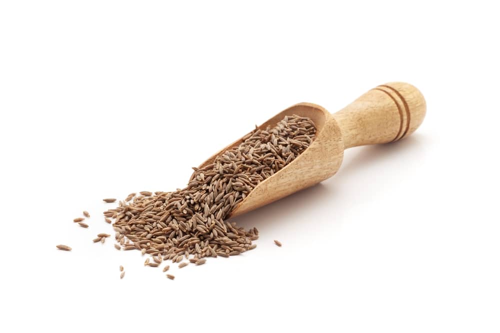 Front View Of A Wooden Scoop Filled With Organic Cumin