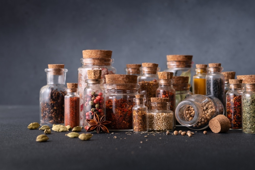 Seasoning (herbs And Spices) In Small Bottles With Cork On Dark Background 