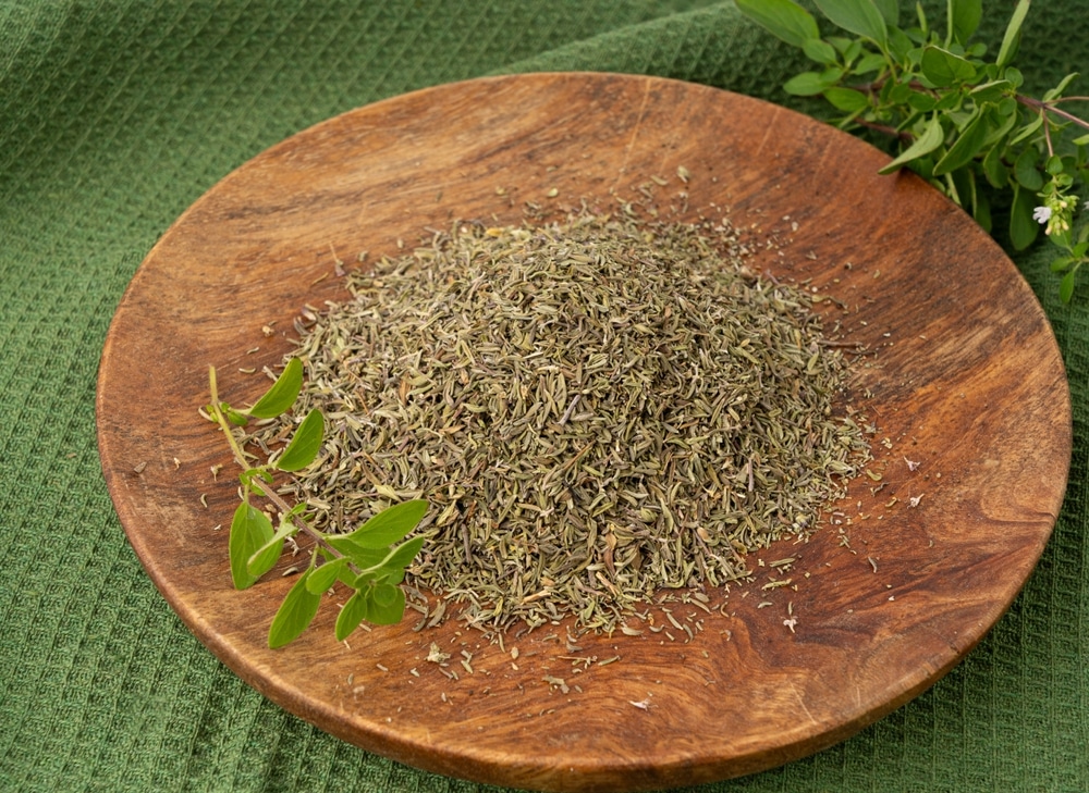 Dry thyme, dried marjoram closeup, oregano pile, ground crushed thyme seasoning