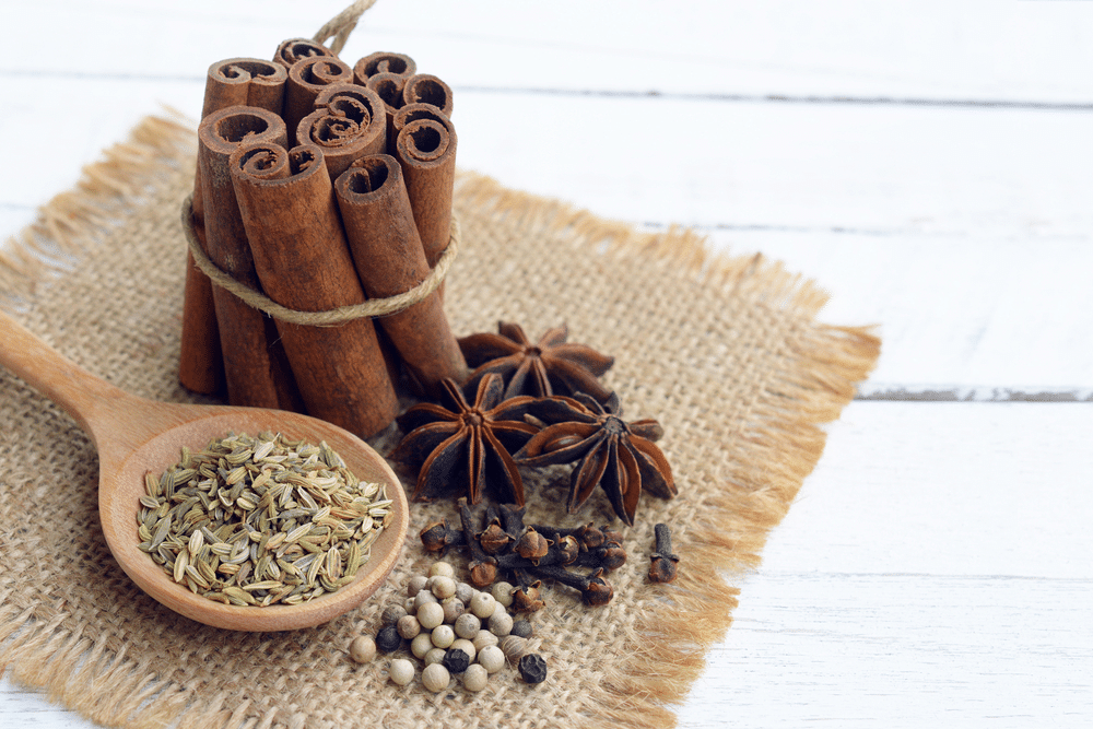 five spices (cinnamon fennel star anise pepper clove) to make chinese five spice powder on wooden background